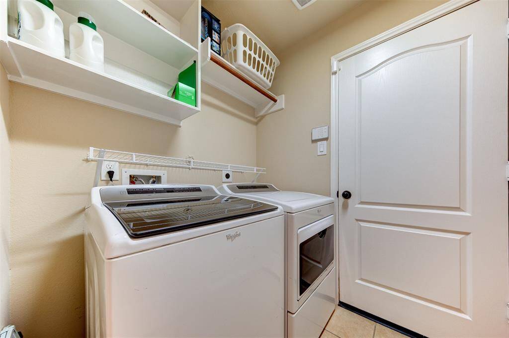 Utility room with built-in shelves & clothes hanging space - door leads to the garage