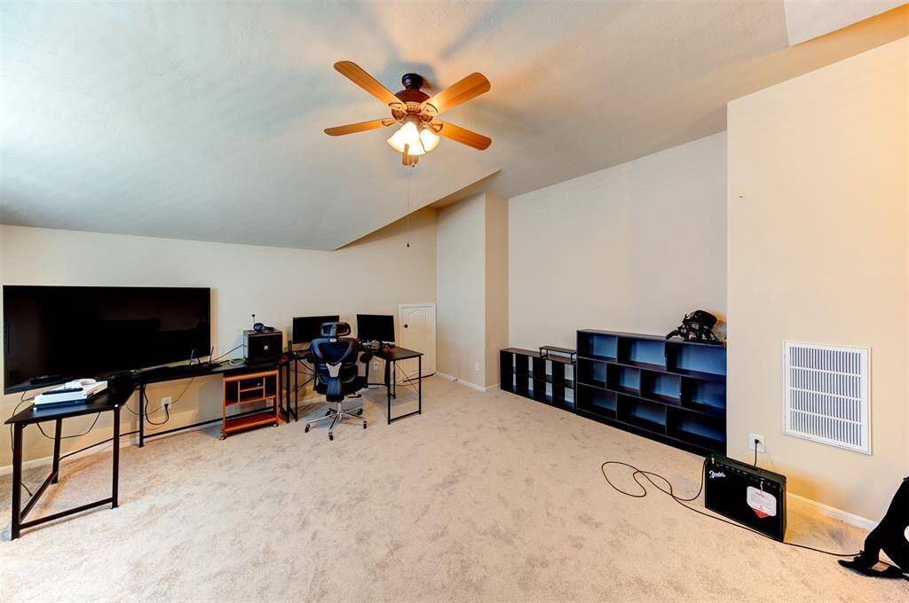 Spacious upstairs game room with attic access door