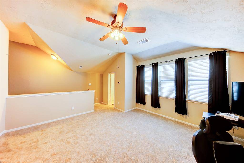 Alternate view of the game room with wall of windows & access to a half bath