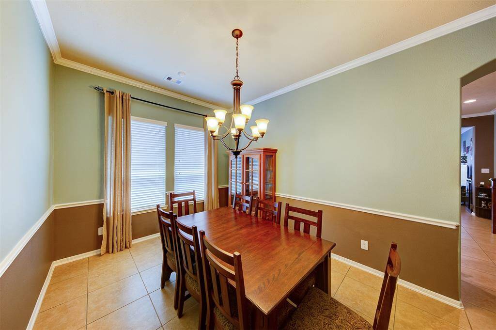 The formal dining room features crown & chair rail molding and a beautiful chandelier