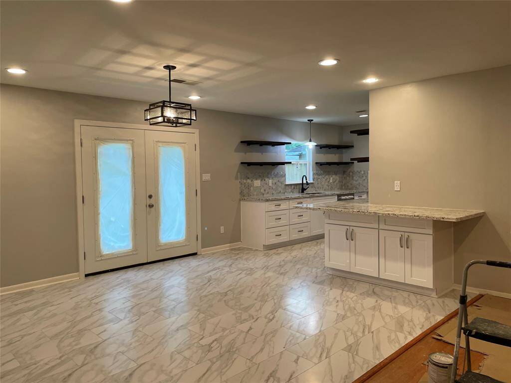 Breakfast area is just off the kitchen with gleaming tile floor and double doors leading to the large backyard.