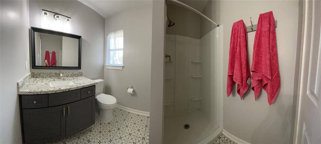 Remodeled guest secondary bathroom with granite counter top and shower.