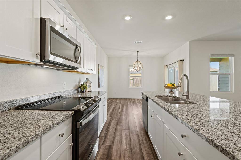 The Kitchen boasts a Whirlpool appliance package including a 4-burner electric range, microwave, and whisper quiet dishwasher.