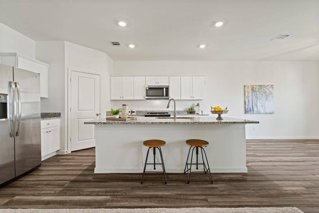 The Kitchen Island boasts an overhang, perfect for providing additional seating and space for tackling weekly meal prep.
