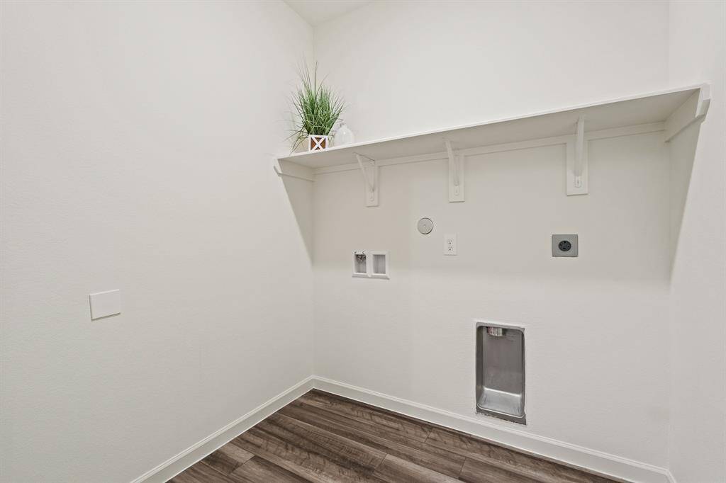 Located directly off the 2-Car Garage, this Laundry Room comes equipped with washer/dryer hookup, a storage shelf, and plenty of room to install a drying rack.