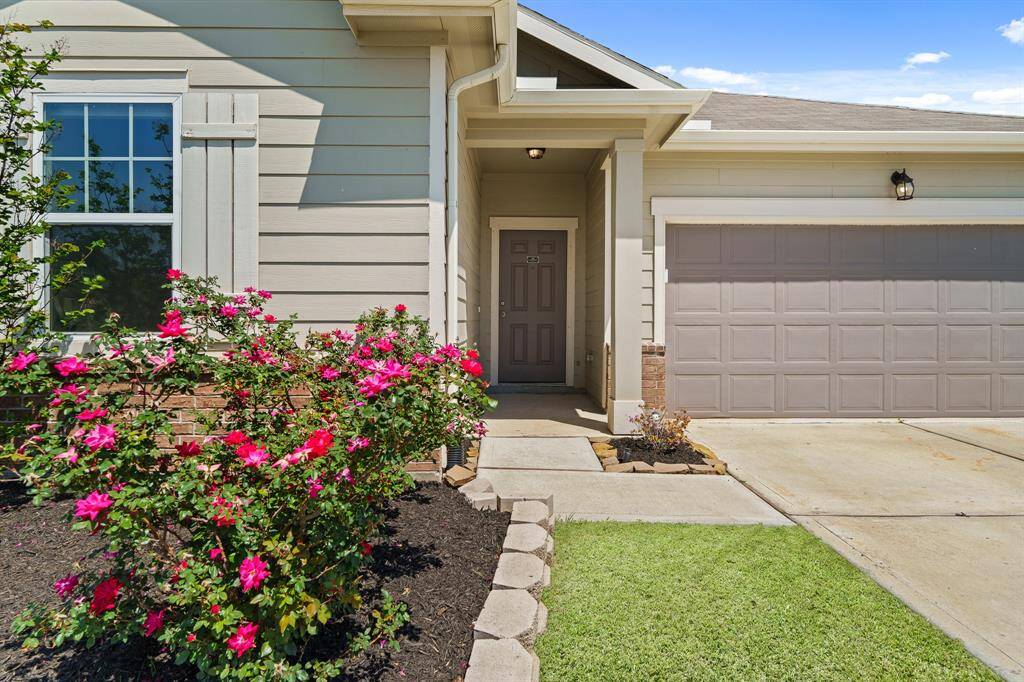 Friends and family will pass this lush and colorful, stacked stone gardening bed on their way to the well-lit Front Porch and entryway door.