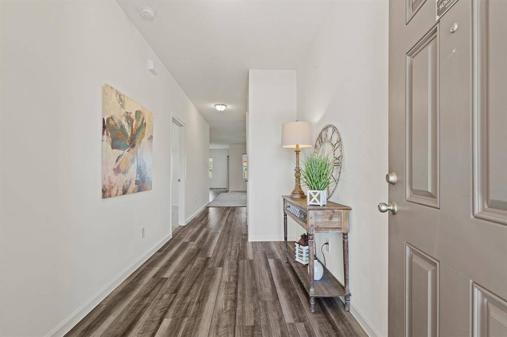 Upon entering the home, the eyes are immediately drawn through this spacious Foyer into the main living space ahead. The variegated wood-like flooring stands out amongst the neutral hues found on the walls and throughout. A coat closet can be found ahead and to the right.