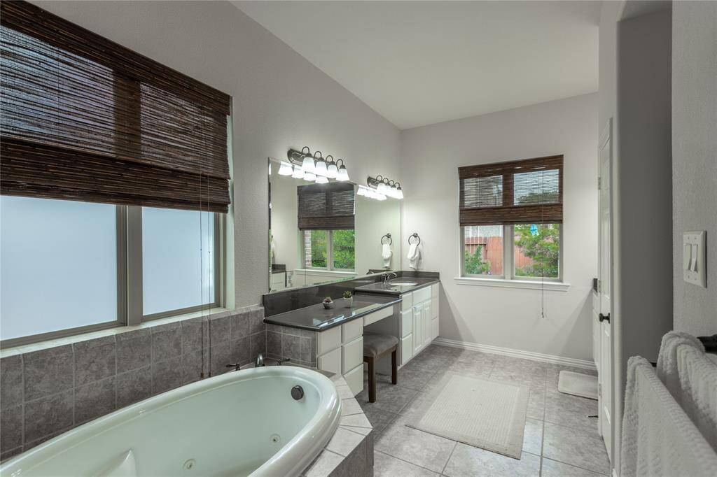 Primary bathroom with two vanities and separate shower and jetted tub.