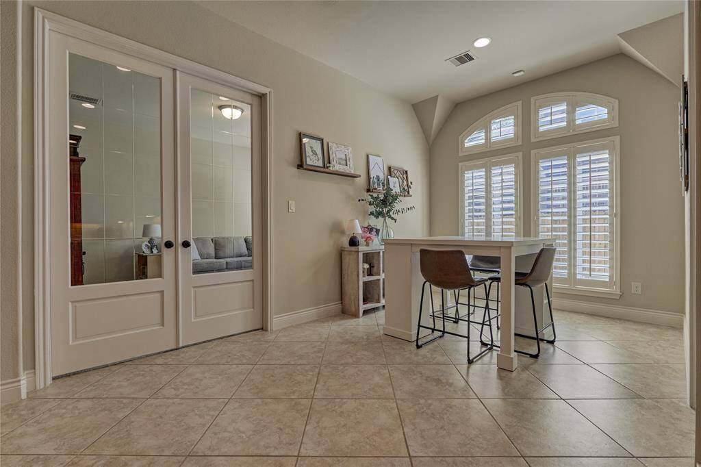 The sunny breakfast area features double French doors leading to the flex room.