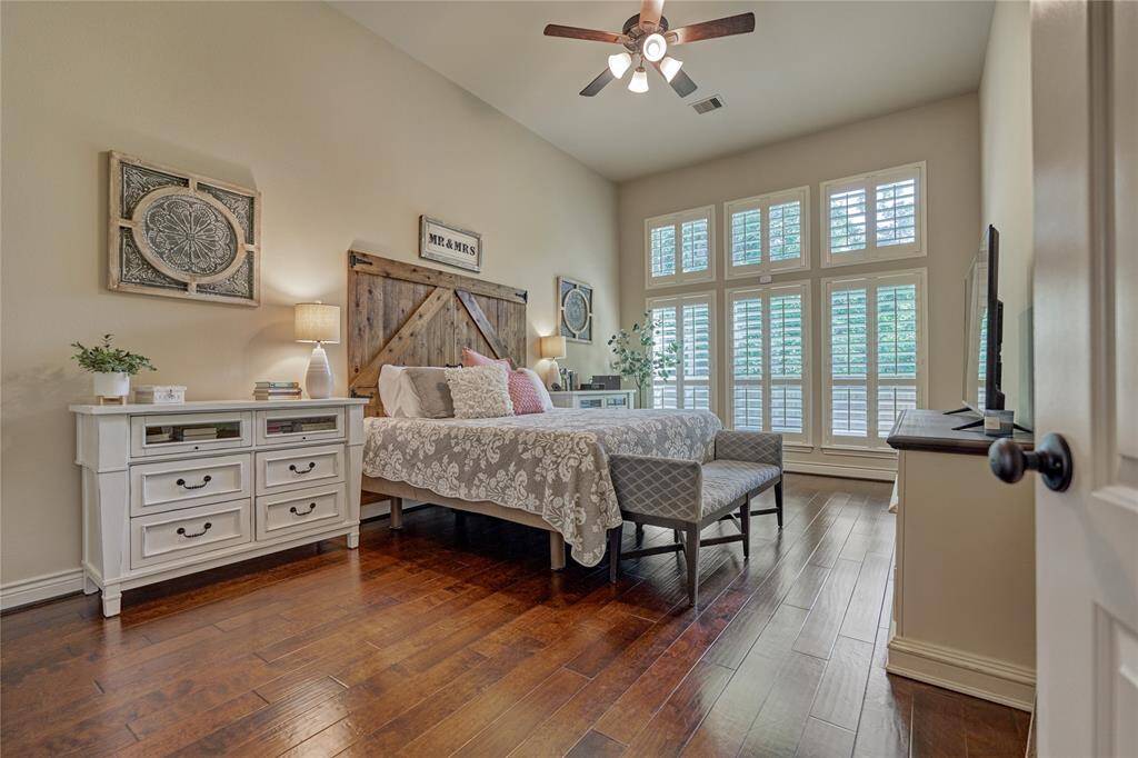 The tranquil primary suite features a wall of windows that overlooks the backyard.