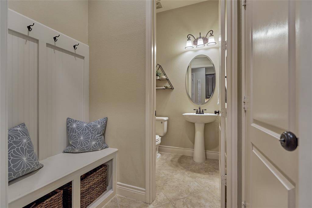 When entering from the tandem three-car garage, you are welcomed by this landing/storage space and a convenient half bath.