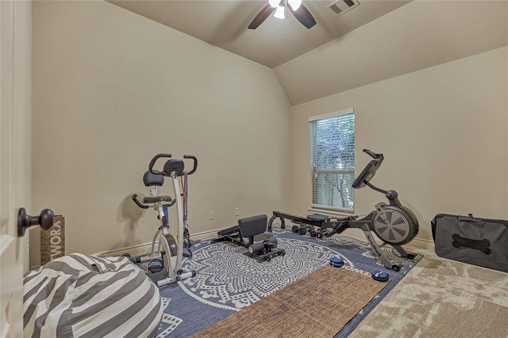 This secondary bedroom is being uses as a workout space and features a walk-in closet which shares a full bathroom.