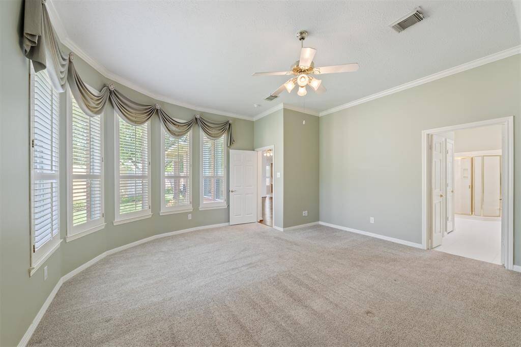 A wall of windows provides lots of natural light and cheerful garden views. The drapes have been removed and the shutters can now be fully opened for an unobstructed view of the mature garden. Double doors lead to the Ensuite Bathroom.