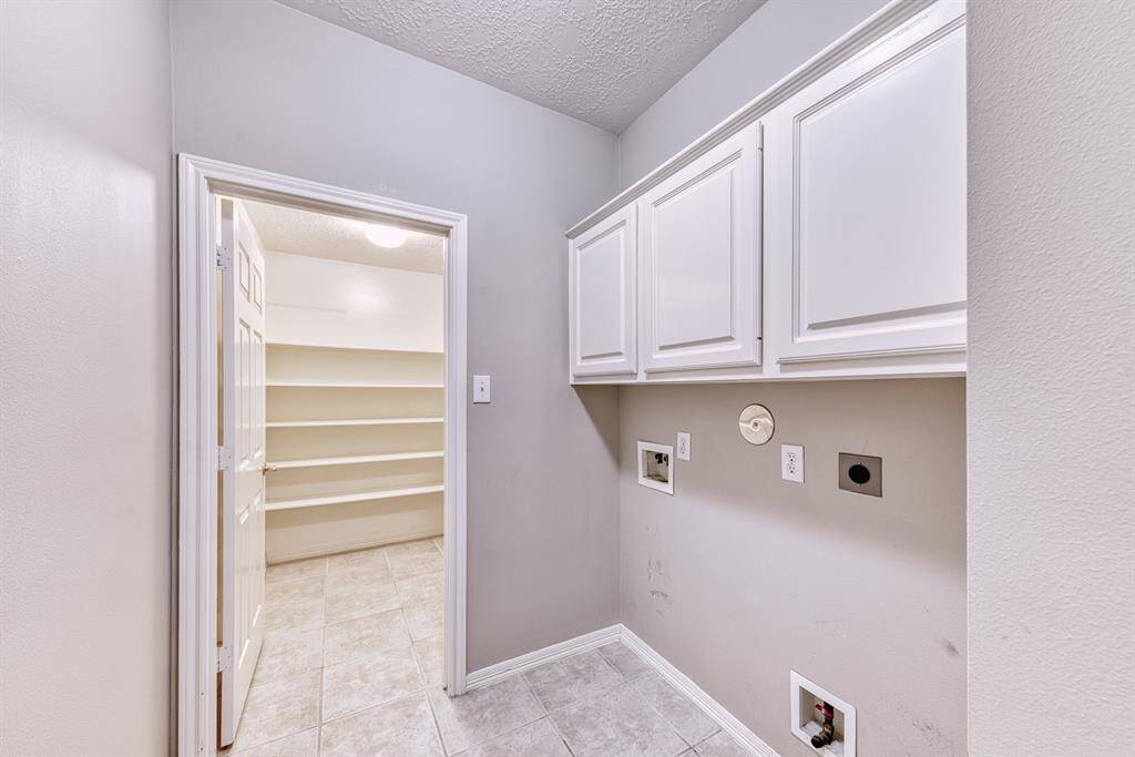 Laundry room has overhead cabinets and a very useful room for storing your holiday decorations, china and crystal, and a multitude of other items!