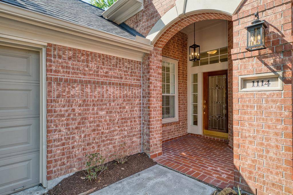 All brick for low maintenance with details like this graceful brick arch framing the covered patio entrance.