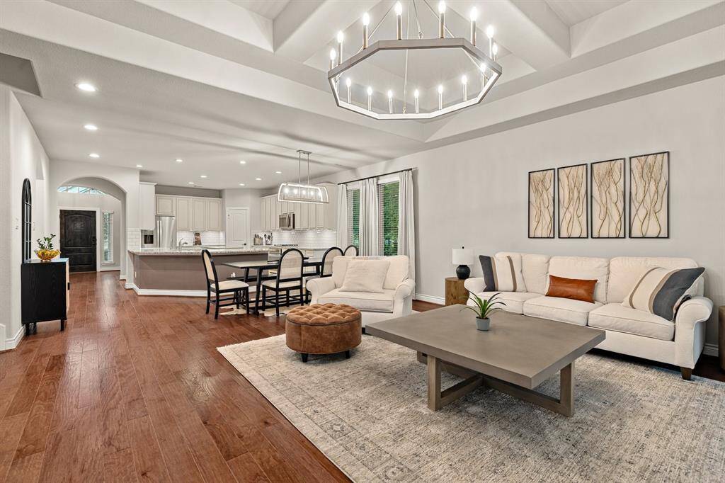 Enjoy the spacious, open-concept kitchen and living area. The kitchen features granite countertops, modern appliances, and light cabinetry. The living space includes a dining area and a cozy seating area near a fireplace, with large windows providing natural light.