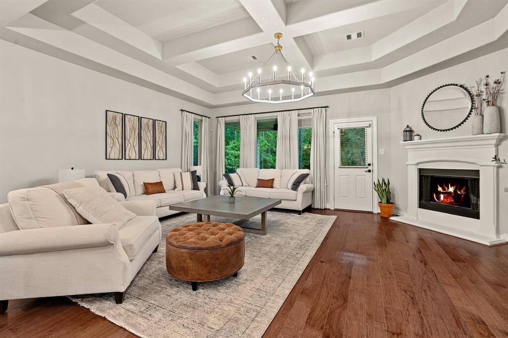Notice the coffered ceiling in the living area with custom lighting and a cozy fireplace.
