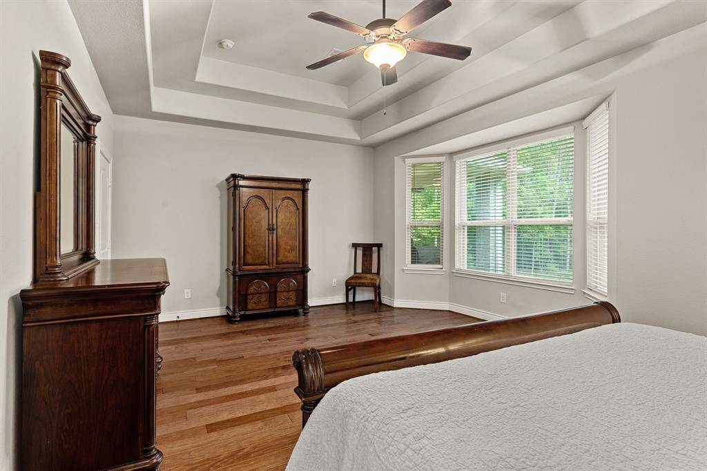 Another view of the Primary Bedroom showing off the massive bay window overlooking the wooded backyard.