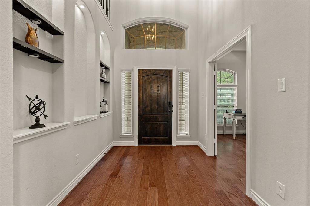 Welcome home to a stunning entrance featuring illuminated arches and elegant double French doors leading to the office.
