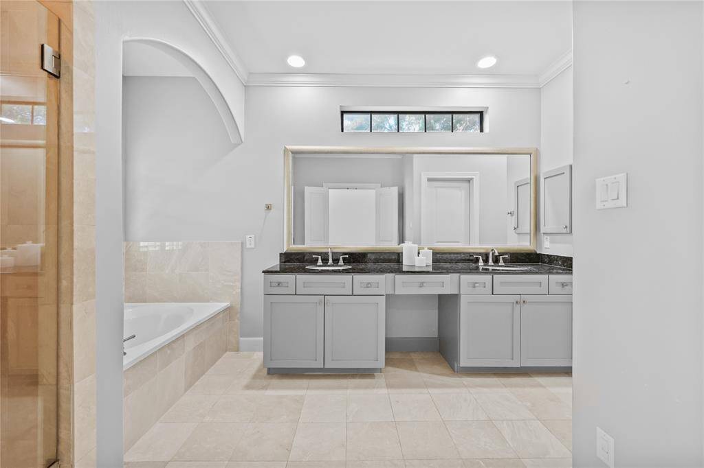Primary bathroom ensuite with dual sinks and large framed mirror