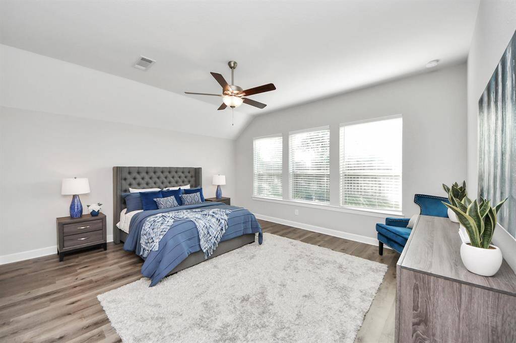 Spacious primary bedroom with sleek carpet-free flooring for a clean and modern feel.