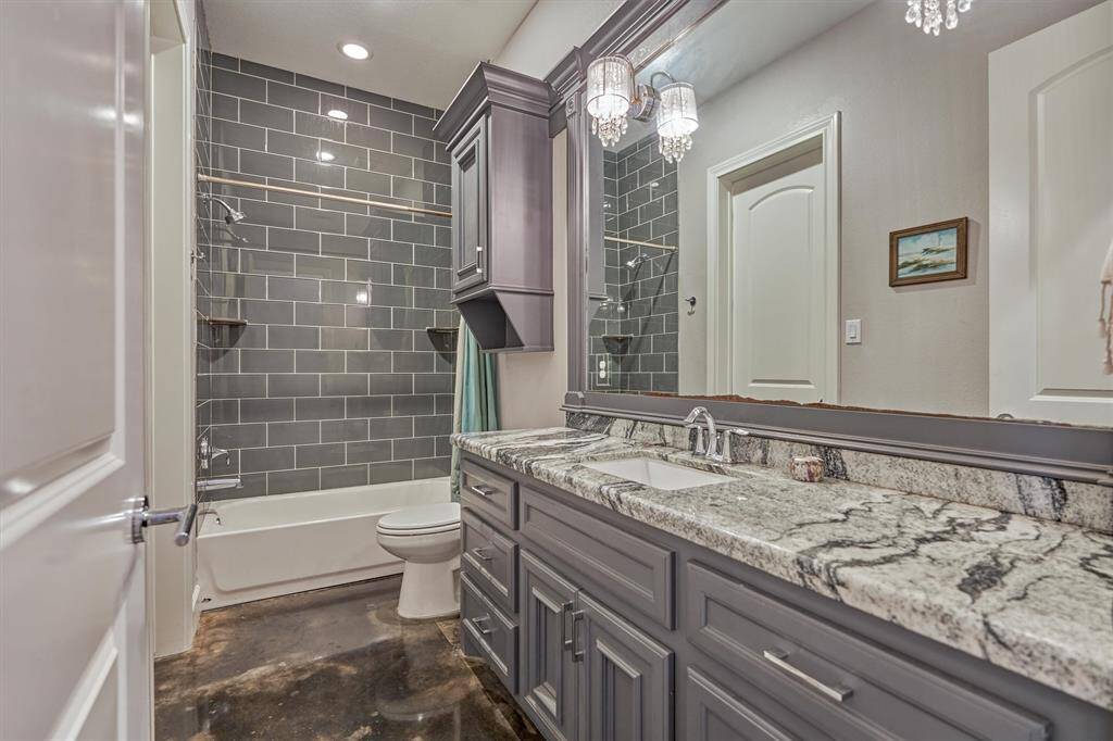 A spacious full bath serves the first bedroom and also offers convenient access from the hallway for guests. High-end finishes are showcased throughout, including custom molding around the mirrors, designer lighting, granite countertops, coordinating millwork, and exquisite tilework in the shower.