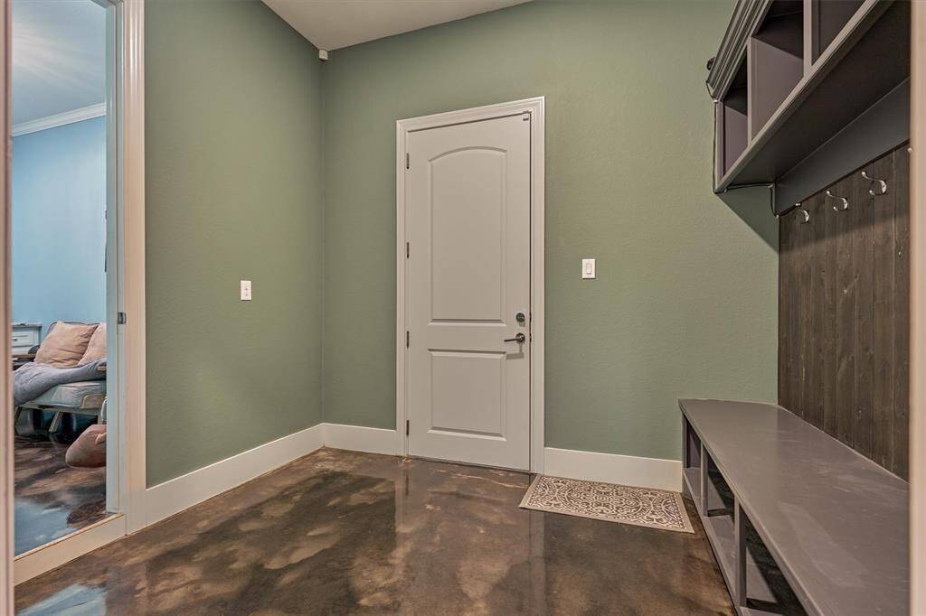 The conveniently located mudroom, just off the garage and entry, features custom built-ins and hooks—perfect for organizing bags, shoes, and everyday essentials.