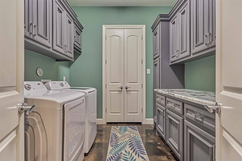 The spacious laundry room is designed for convenience, featuring ample storage cabinets, a generous folding counter, and double doors that open to an additional large storage closet. Washer and dryer are included with the home, making this space fully equipped and move-in ready.