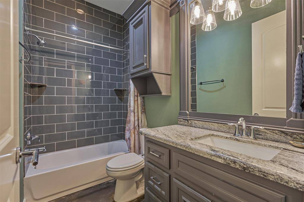 The en-suite bath for the second guest bedroom highlights the same custom millwork and high-end finishes found throughout the home, creating a cohesive and refined design.