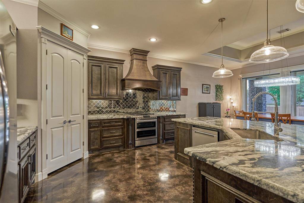As you step into the kitchen, your eye is drawn to the custom vent hood above the gas range and the stunning granite countertops. A generous walk-in corner pantry offers versatile storage space to keep everything organized and within reach.