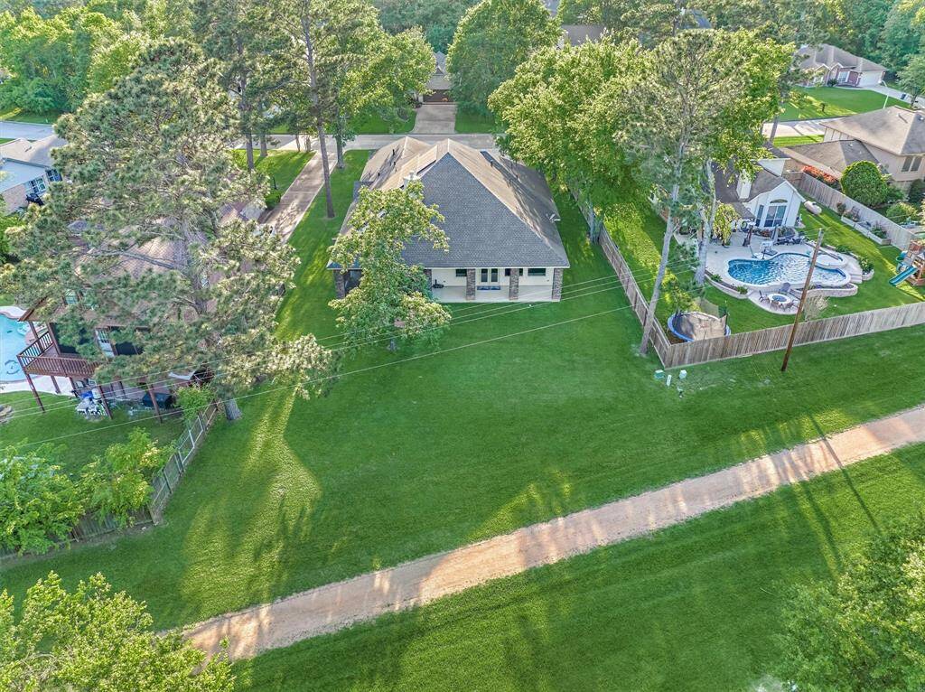 Another view showcases the expansive backyard and the peaceful walking path just beyond. Deer are commonly seen grazing and wandering through this tranquil, nature-filled setting.