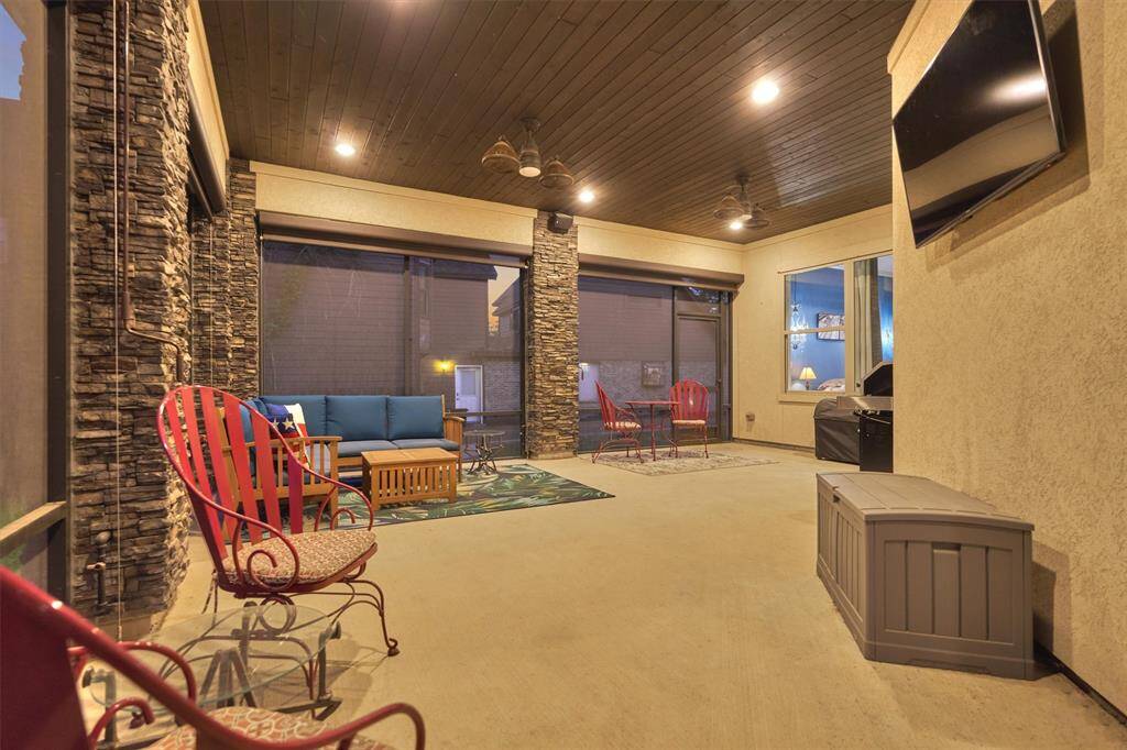 The screened-in porch offers a year-round retreat, perfect for unwinding in comfort. Featuring a warm tongue and groove ceiling, stone accents, and ample space for seating, this inviting area combines style and relaxation with beautiful outdoor views.