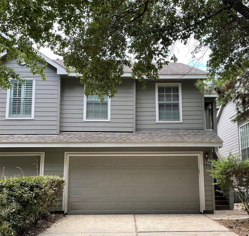 The front is shaded by trees, offering a cozy and inviting appearance.