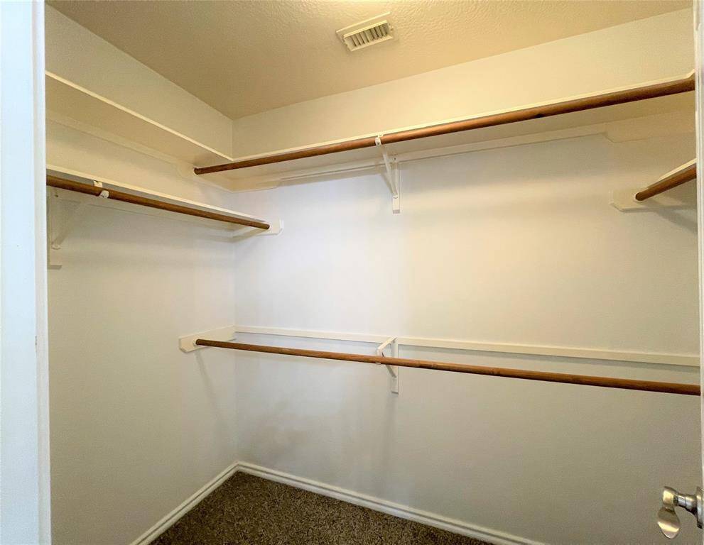 Expansive primary closet with ample shelving and hanging space for all your storage needs.