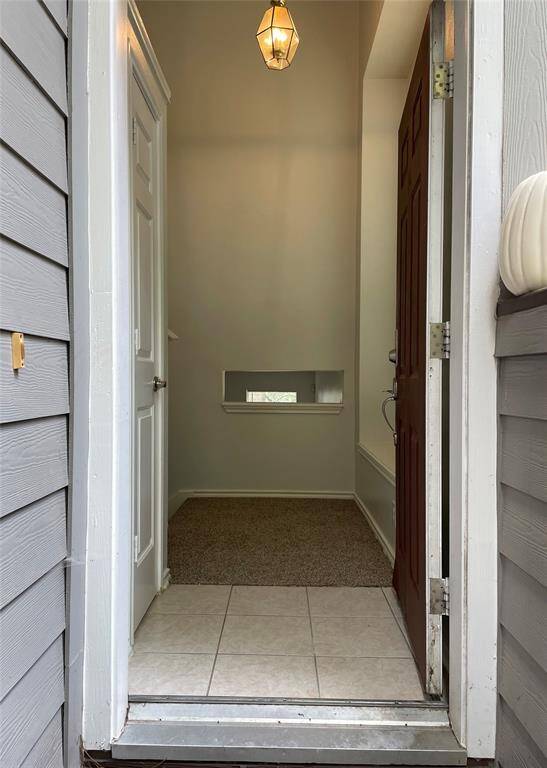 This inviting entryway features natural lighting from the wall to wall windows on the right side of the wall