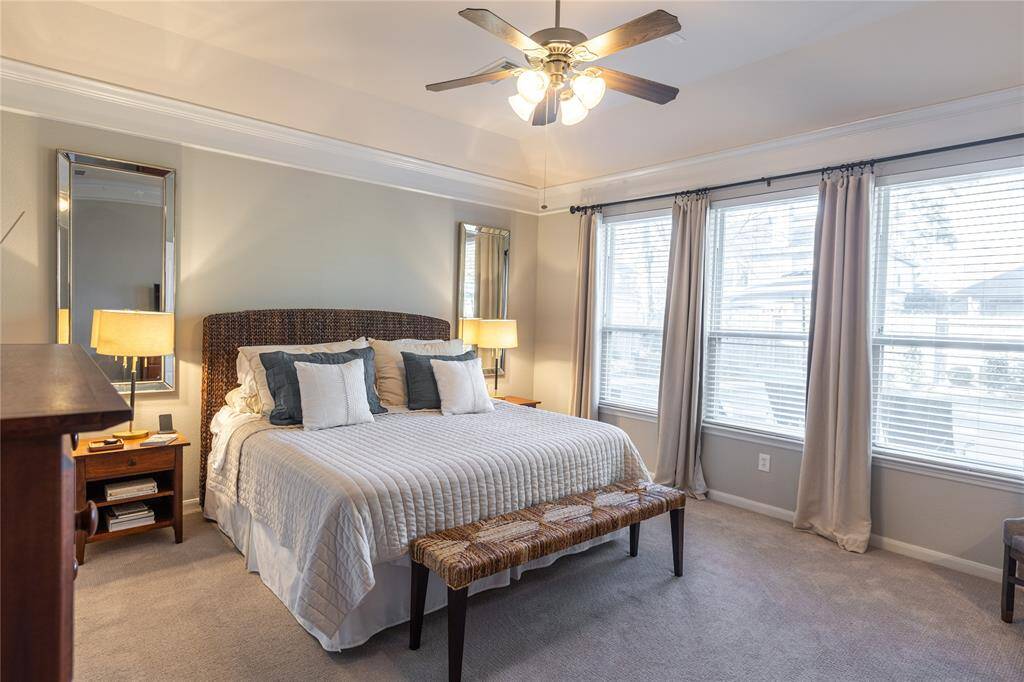 Primary ensuite features raised ceiling, crown molding, soothing paint choice and view of the pool