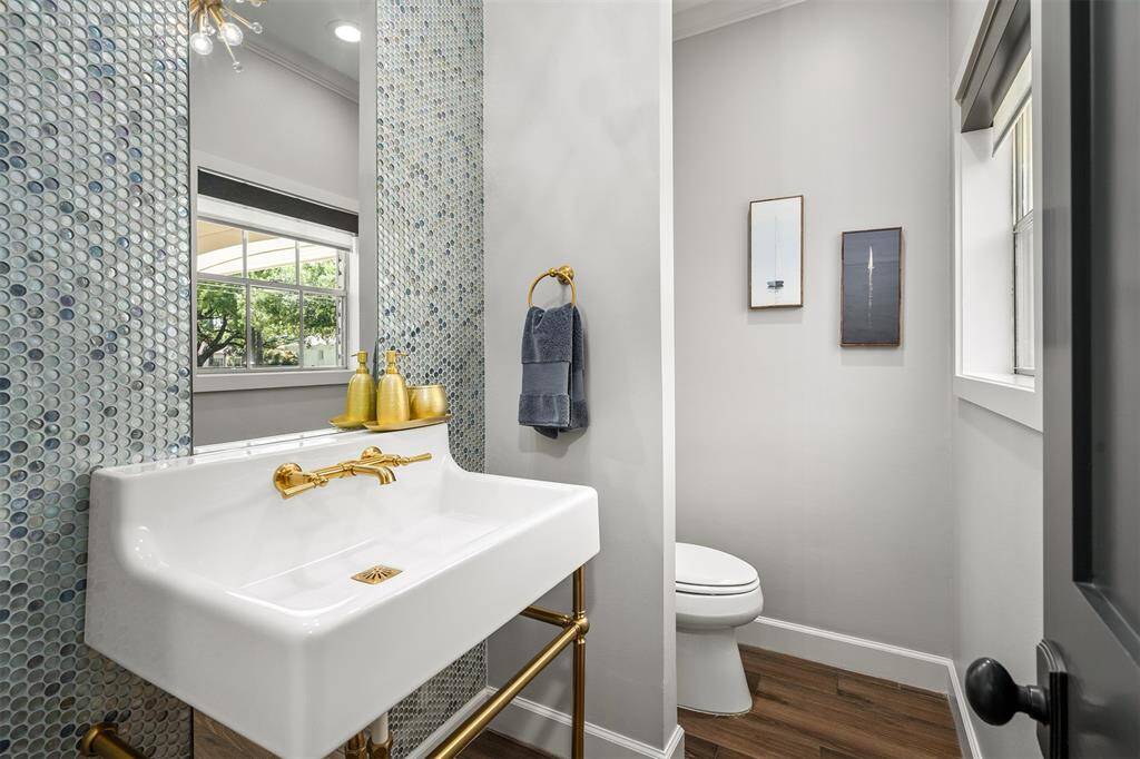 Stunning powder room with English brass fixtures and designer glass tiles.