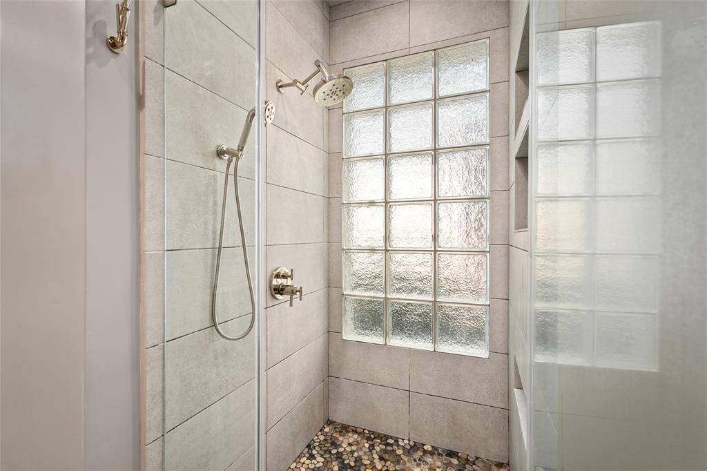A walk-in shower with 3 shower heads.