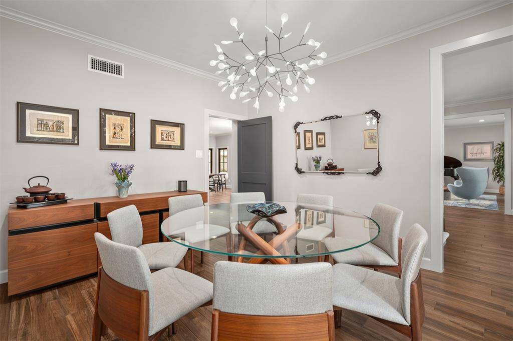 A large dining room with a designer chandelier.