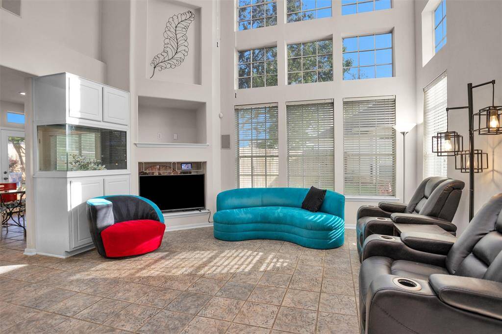 This spacious living room features tall ceilings, large windows for ample natural light   Ideal for relaxation and entertaining.