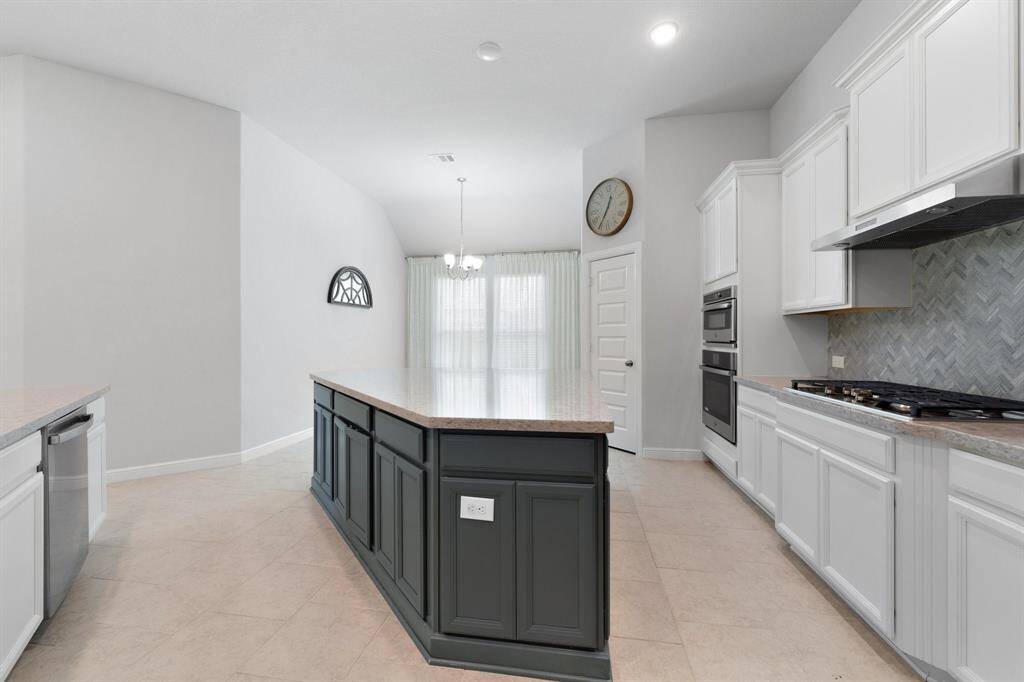 The oversized kitchen island is a true centerpiece, complemented by a cozy breakfast nook filled with natural light—perfect for casual meals or morning coffee.