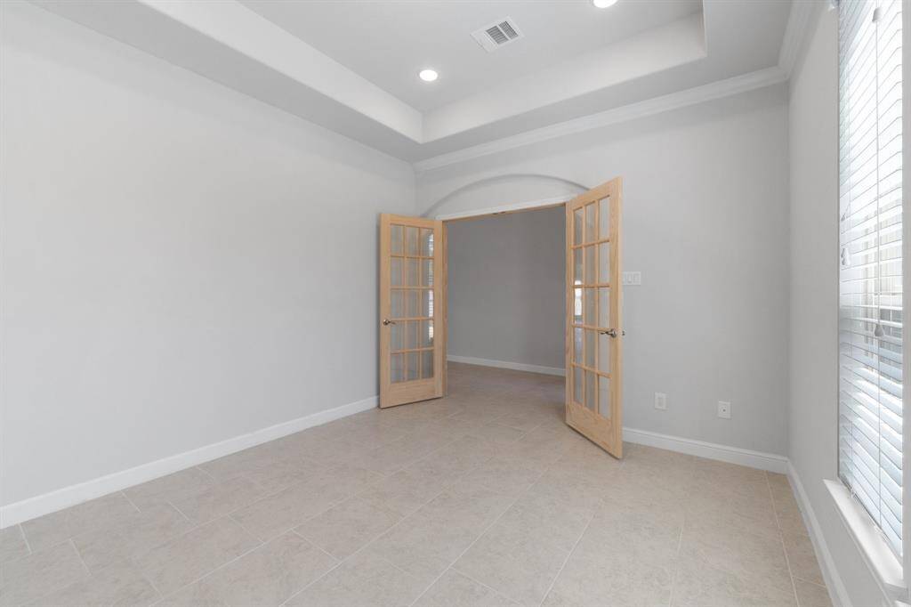 This dedicated home office space features French doors for privacy and a spacious layout ideal for productivity and comfort.
