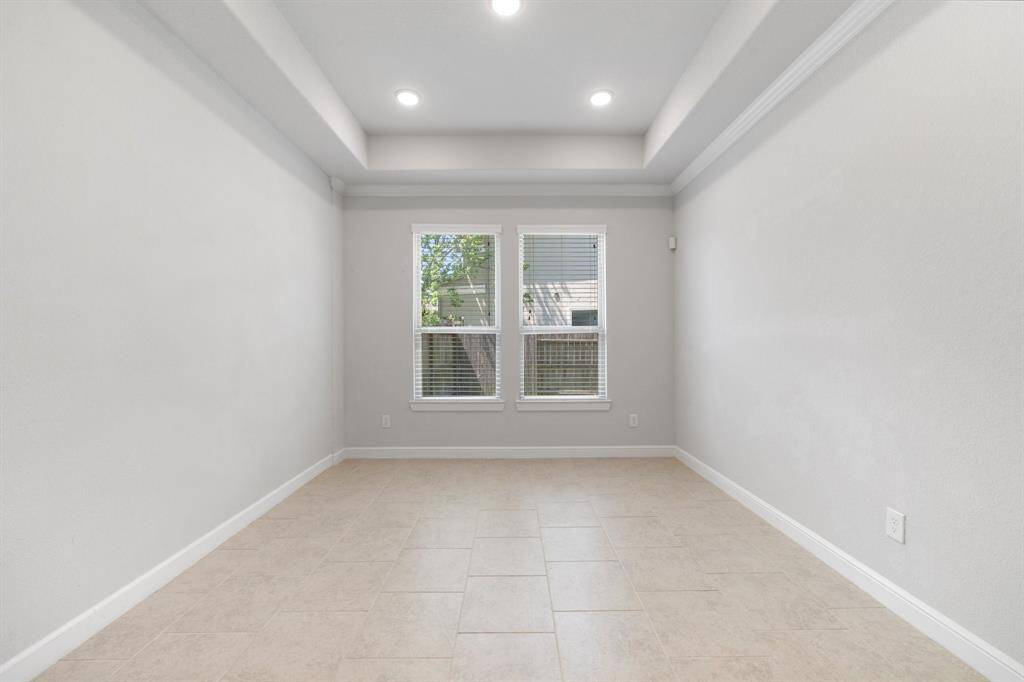 Bright and airy dining room with tray ceilings and recessed lighting, perfect for hosting gatherings or enjoying everyday meals.