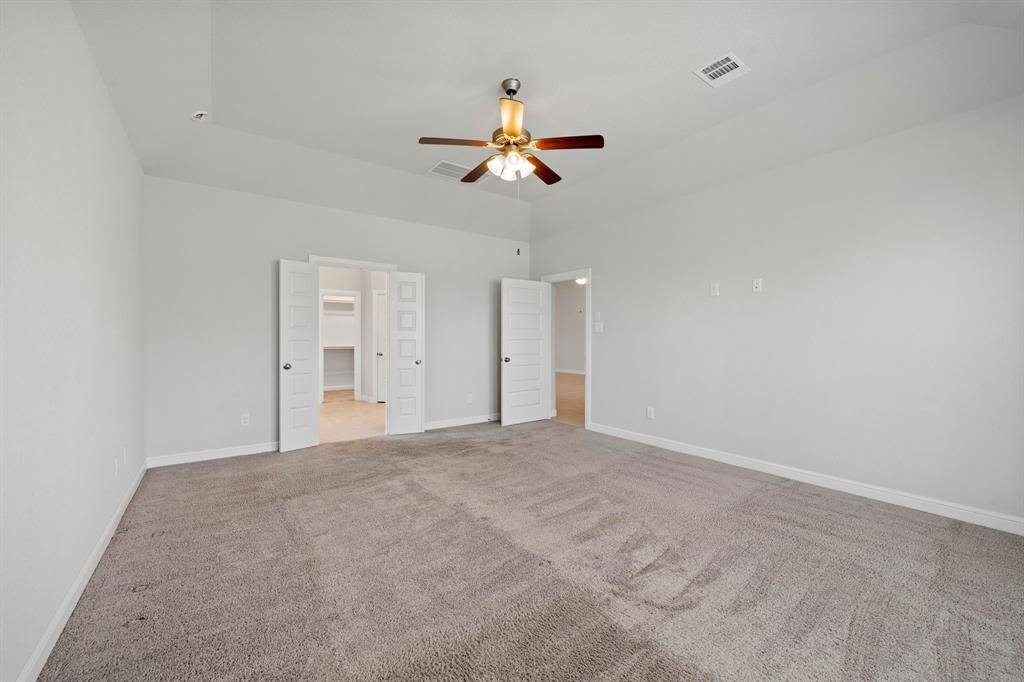 Generously sized primary retreat with double-door entry to the ensuite bathroom and walk-in closet.