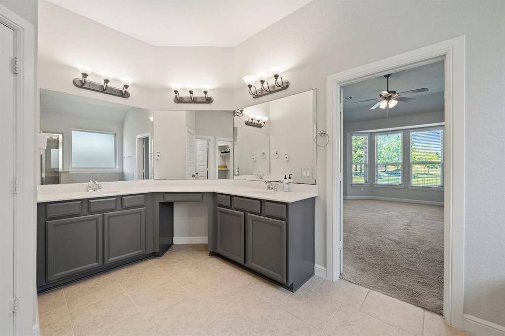 Elegant primary bath with dual vanities, large mirrors, and upgraded light fixtures—designed for both luxury and functionality.