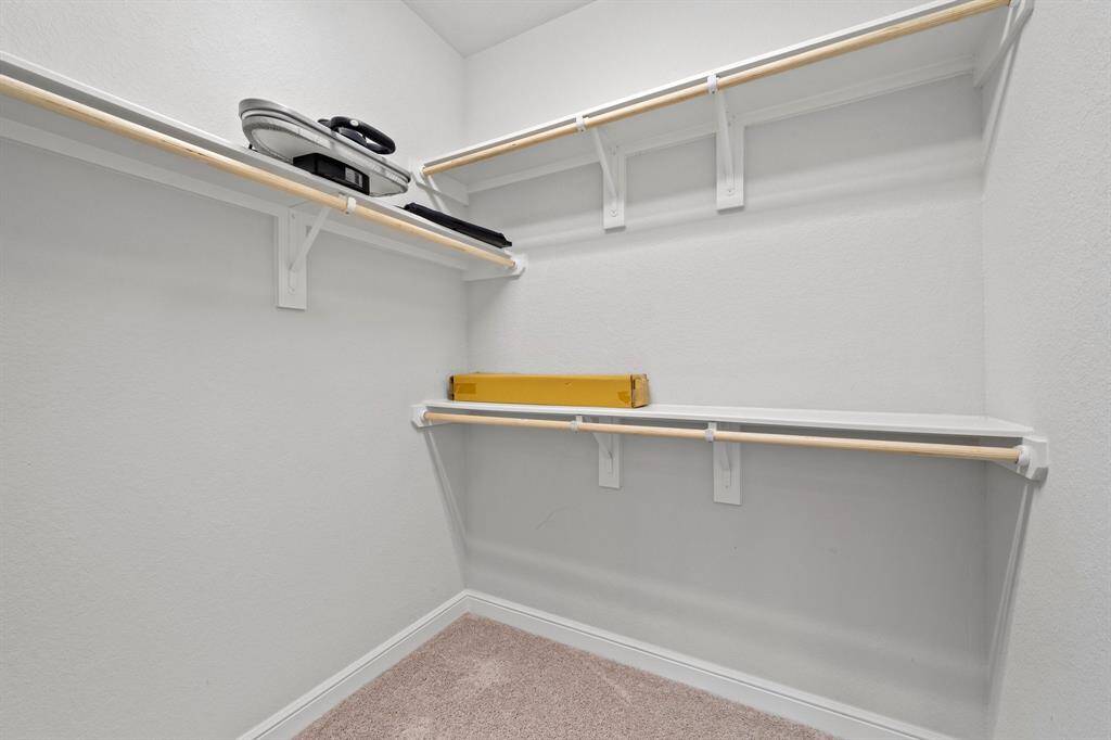 Another angle of the closet shows additional hanging space and deep corner shelving for maximum storage.