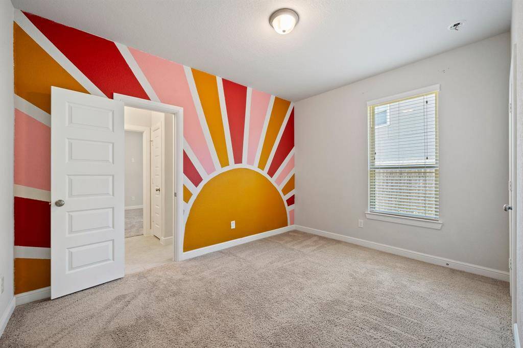 Another bright secondary bedroom with an eye-catching sunburst mural, ideal for a creative or youthful space.