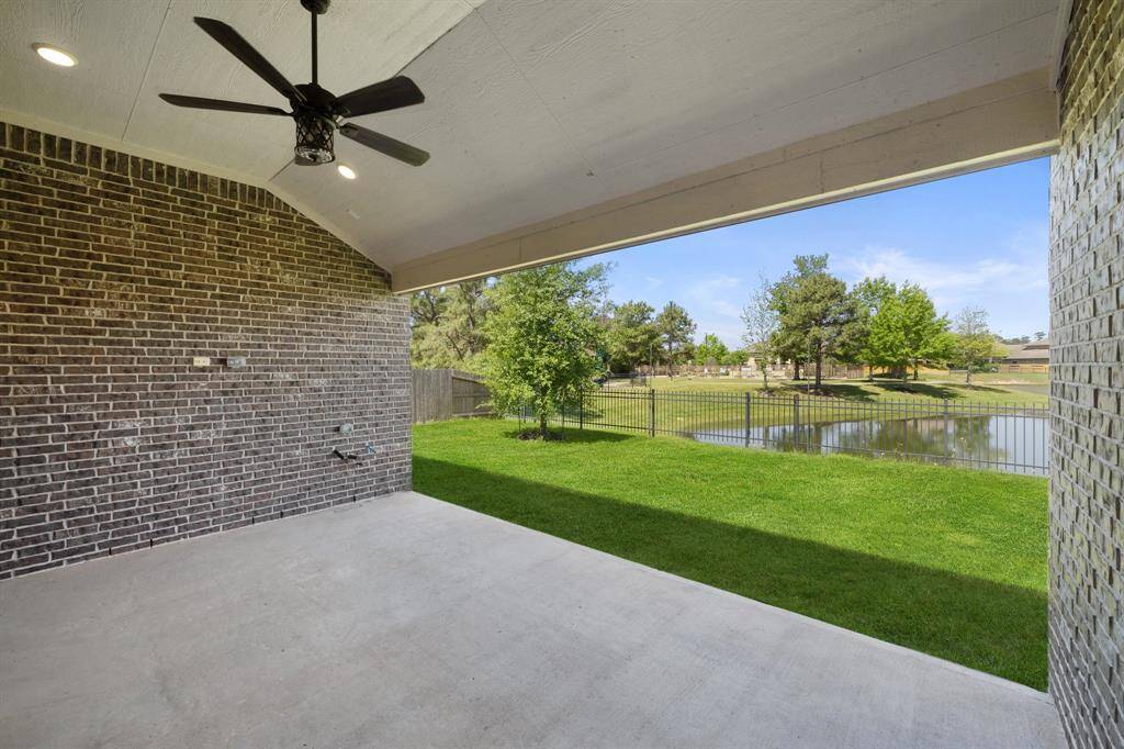 Relax under the extended covered patio featuring recessed lighting, a ceiling fan, and tranquil views of the serene lake just beyond your backyard.