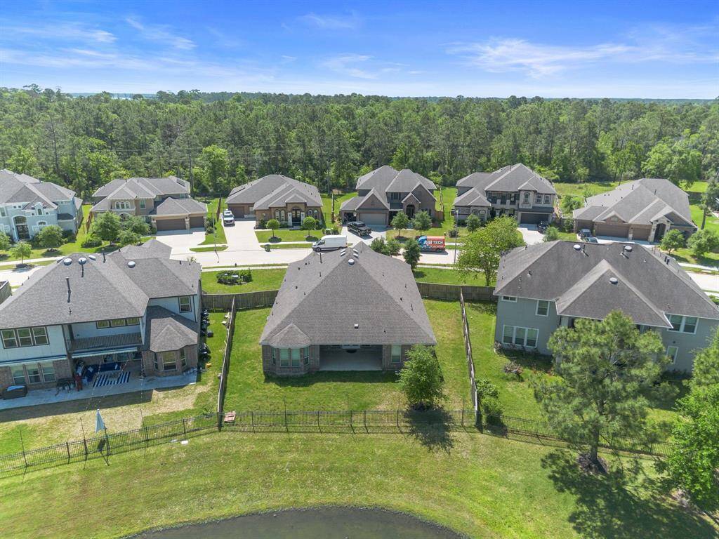 Breathtaking view of the home’s backyard backing to a peaceful lake and greenbelt, offering added privacy and natural beauty.