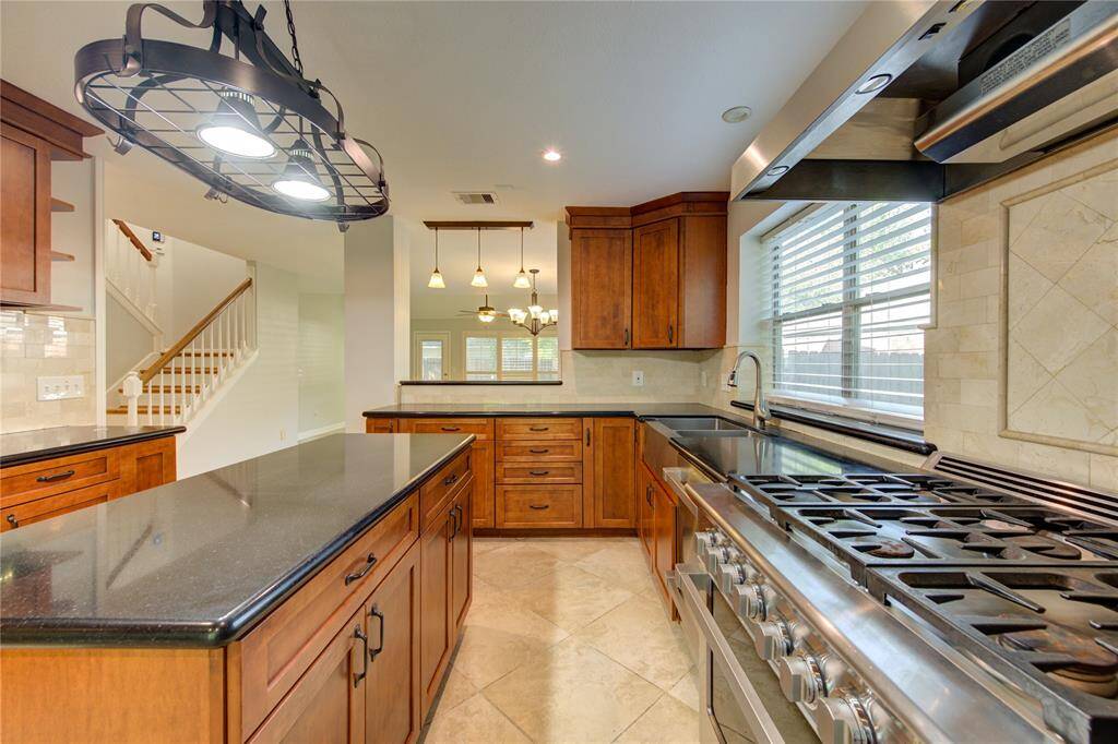 6 burner gas stove with large oven & vent hood. Pass through area in kitchen to dining room.